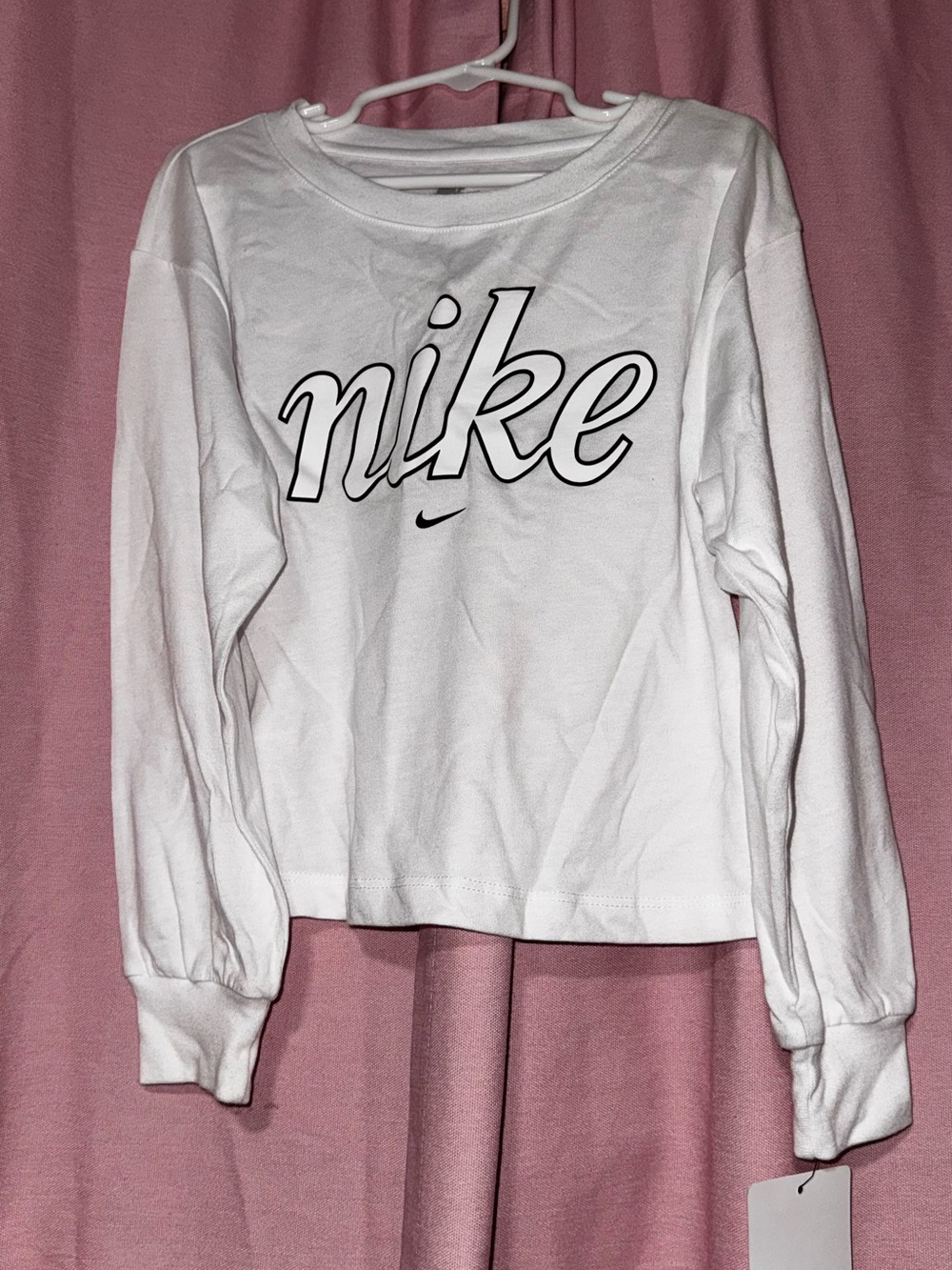This white, long-sleeve T-shirt featuring the Nike logo is a stylish